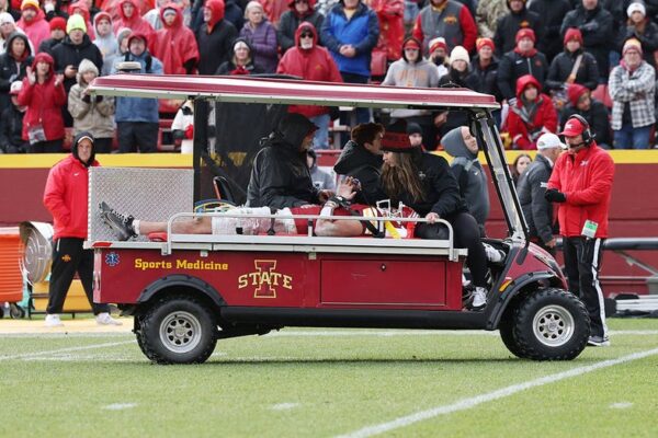 Iowa State player taken off field on a stretcher, admitted to hospital following collapse due to forceful collision.